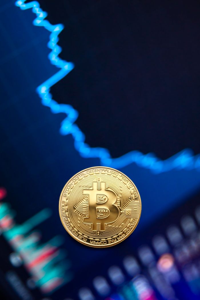 Golden bitcoin coin on background of graph showing value growth of cryptocurrency in stock exchange